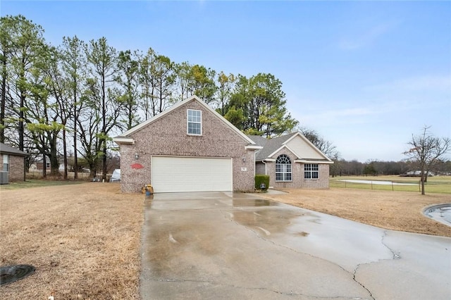 view of front of home featuring a garage, a front yard, concrete driveway, and brick siding