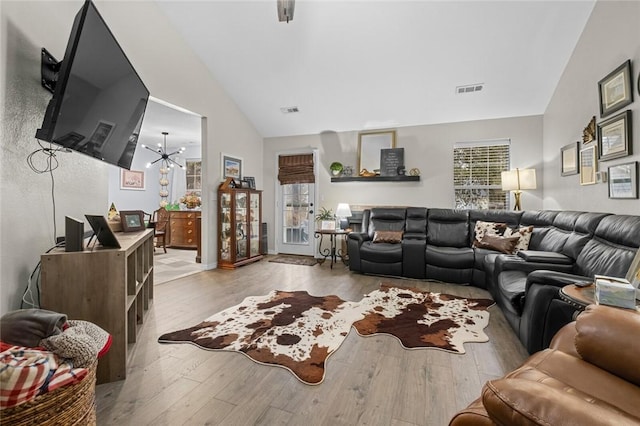 living area featuring plenty of natural light, visible vents, and wood finished floors