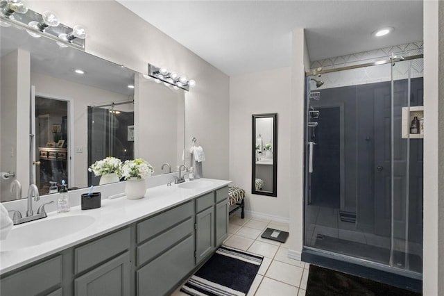 bathroom with double vanity, a stall shower, a sink, and tile patterned floors