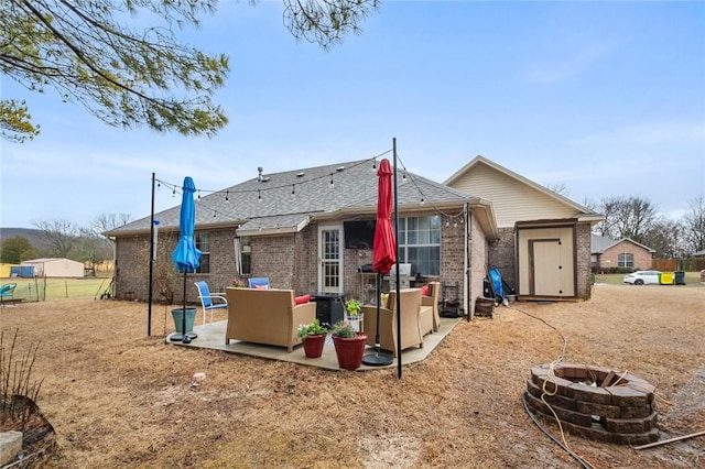 back of property with brick siding, a patio area, an outdoor living space with a fire pit, and fence