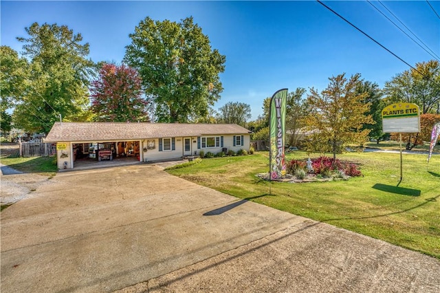 single story home with driveway, a carport, a front yard, and fence