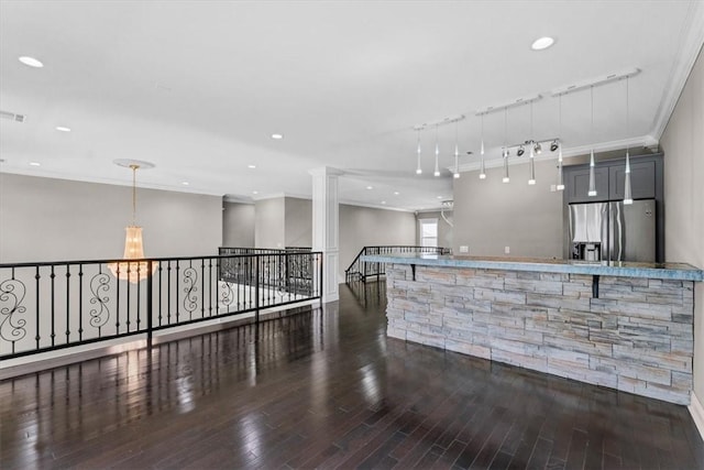 interior space with ornamental molding, stainless steel refrigerator with ice dispenser, wood finished floors, and recessed lighting