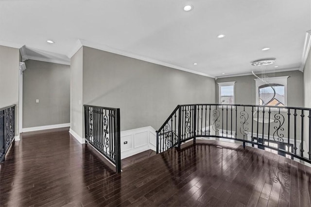 interior space with crown molding, wood finished floors, an upstairs landing, and recessed lighting