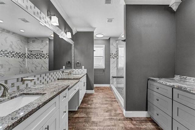 bathroom featuring a walk in shower, double vanity, a sink, and wood finished floors