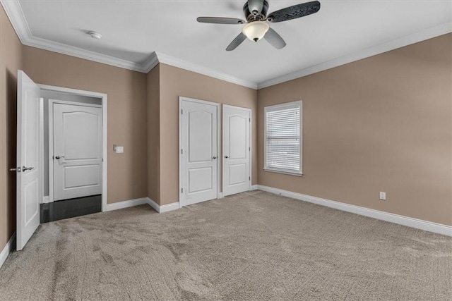 unfurnished bedroom featuring carpet floors, ornamental molding, and baseboards