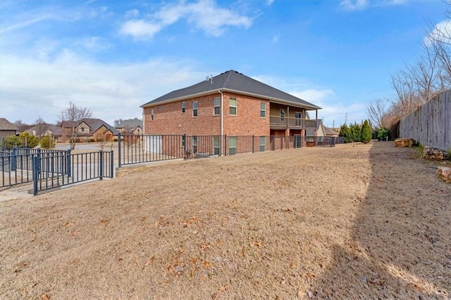 back of house with brick siding and fence