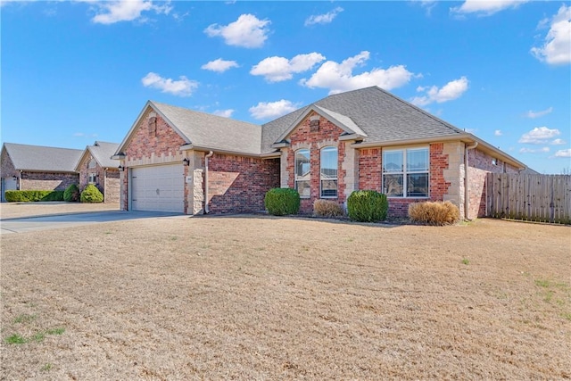 ranch-style home with brick siding, roof with shingles, fence, a garage, and driveway