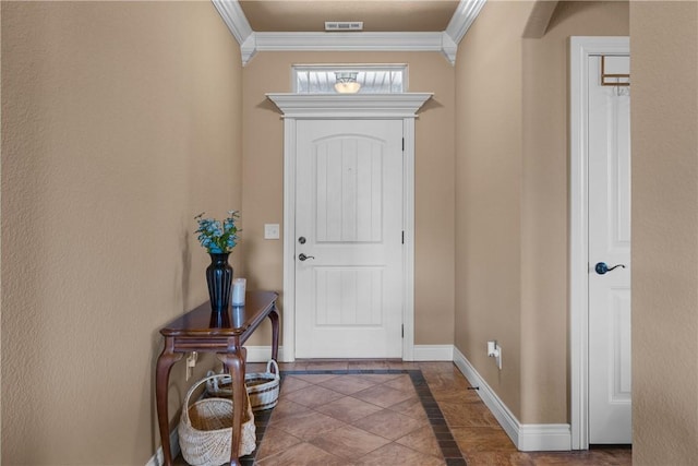 entryway with baseboards, visible vents, and crown molding