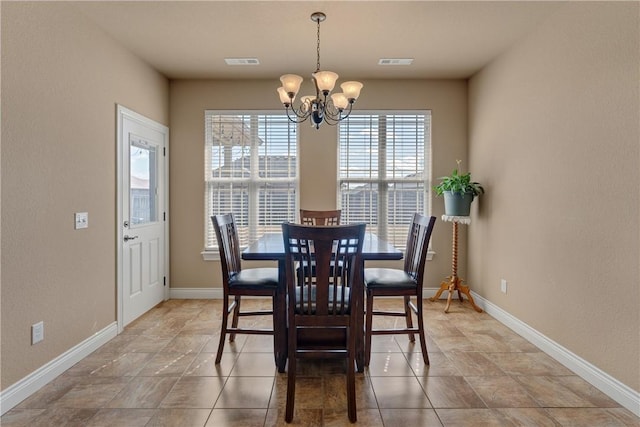 dining area with baseboards, visible vents, and a notable chandelier