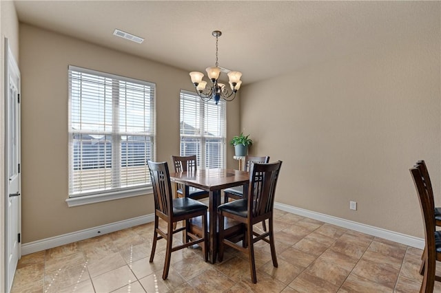 dining area featuring visible vents, baseboards, and an inviting chandelier