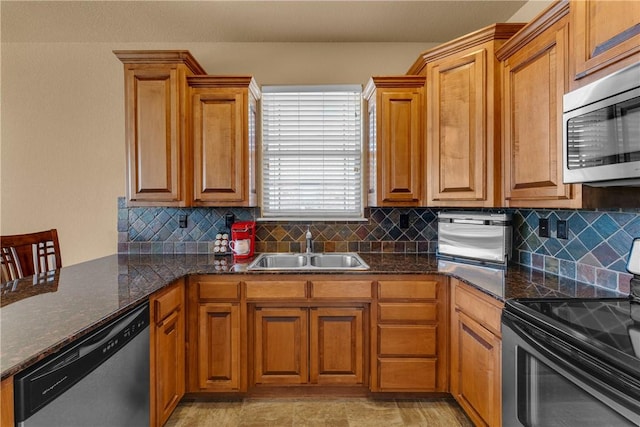 kitchen featuring decorative backsplash, appliances with stainless steel finishes, brown cabinets, and a sink