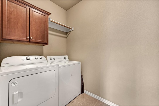 laundry room with washer and dryer, baseboards, light tile patterned floors, and cabinet space