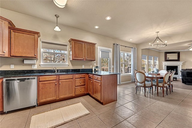 kitchen with brown cabinetry, a peninsula, open floor plan, a sink, and dishwasher