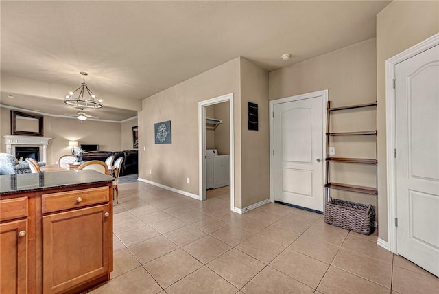 kitchen featuring independent washer and dryer, baseboards, an inviting chandelier, and light tile patterned floors
