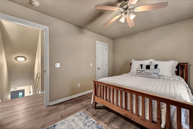 bedroom featuring baseboards, a ceiling fan, and wood finished floors