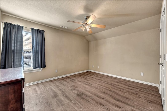 spare room with baseboards, ceiling fan, wood finished floors, and visible vents