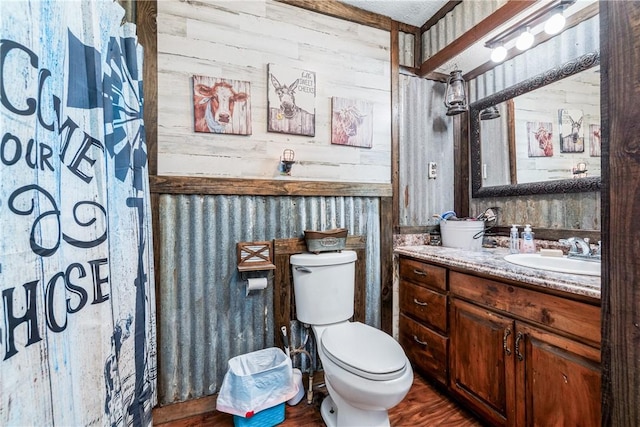 full bath featuring toilet, vanity, and wood finished floors