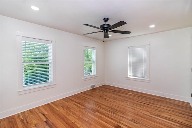 empty room with light wood finished floors, baseboards, and visible vents