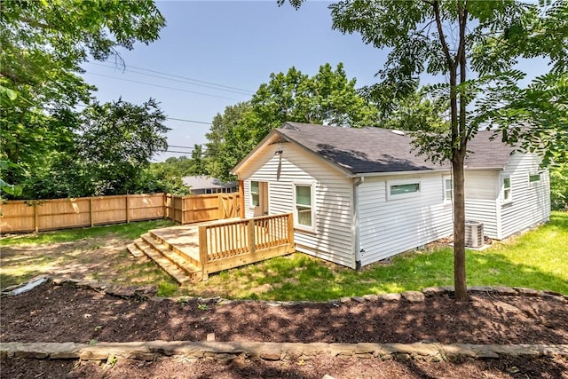 back of house featuring a shingled roof, fence, a deck, a yard, and central air condition unit