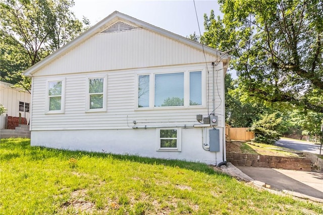 rear view of property featuring fence and a yard