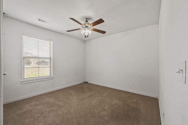 spare room featuring baseboards, carpet flooring, visible vents, and a ceiling fan