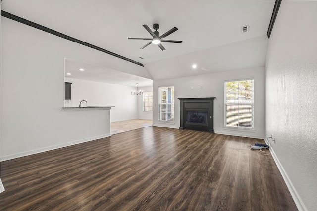 unfurnished living room featuring a wealth of natural light, a fireplace, visible vents, and dark wood-style flooring