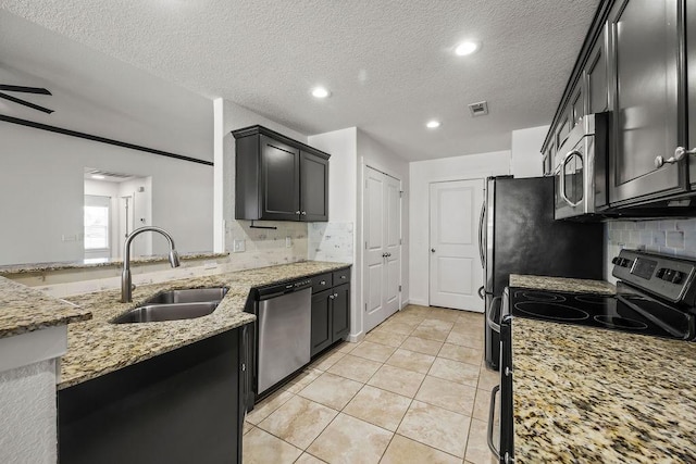 kitchen with light tile patterned floors, visible vents, light stone countertops, stainless steel appliances, and a sink