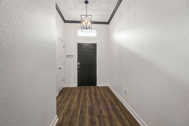 foyer entrance featuring baseboards, a textured wall, and crown molding