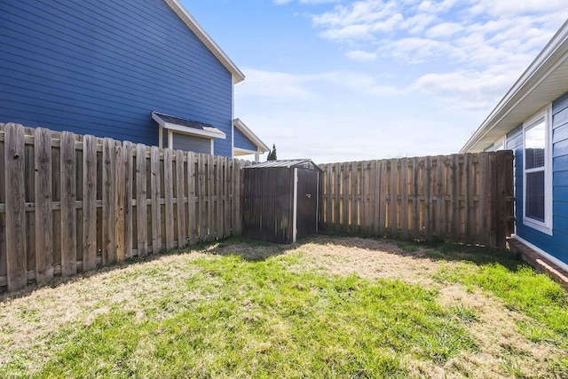 view of yard featuring a fenced backyard, an outdoor structure, and a storage shed