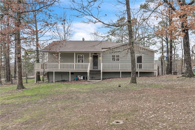 view of front facade featuring stairs, a deck, and a shingled roof