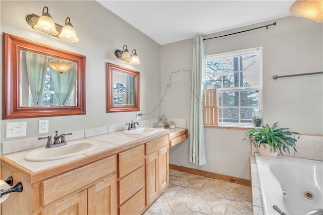 bathroom with a sink, a jetted tub, baseboards, and double vanity