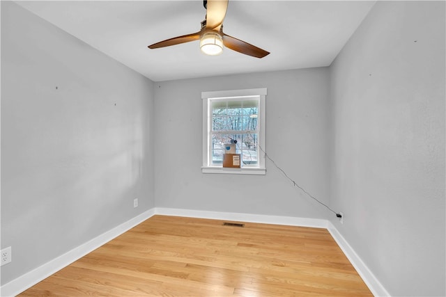 unfurnished room with visible vents, ceiling fan, baseboards, and wood finished floors