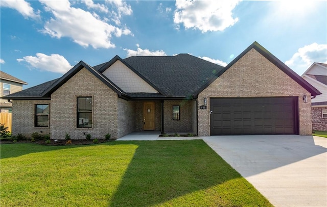 view of front facade featuring an attached garage, brick siding, driveway, and a front yard