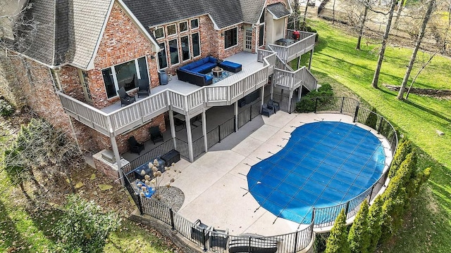 view of pool with a fenced in pool, fence, a deck, a patio area, and a lawn