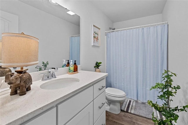 full bathroom featuring wood finished floors, a shower with shower curtain, vanity, and toilet