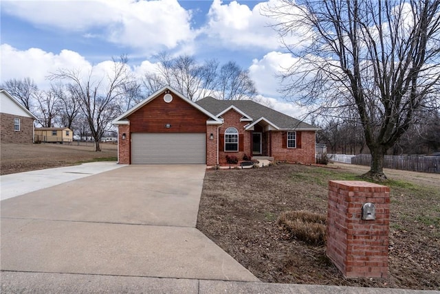 view of front of home featuring concrete driveway, brick siding, fence, and an attached garage