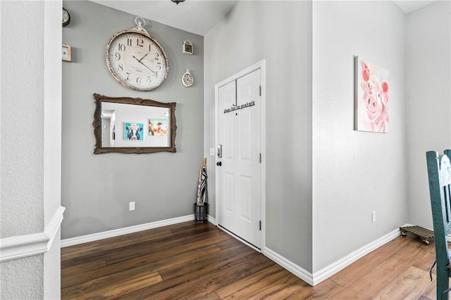 foyer featuring baseboards and wood finished floors