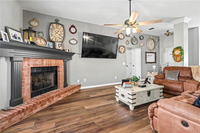 living room with dark wood-style flooring, a fireplace, visible vents, a ceiling fan, and baseboards