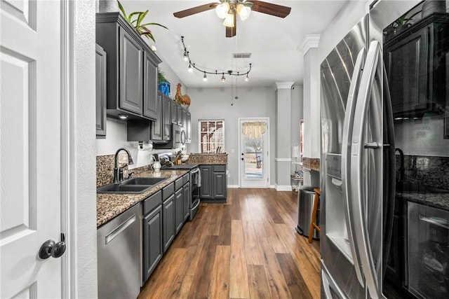 kitchen with dark wood-style floors, gray cabinetry, appliances with stainless steel finishes, stone countertops, and a sink