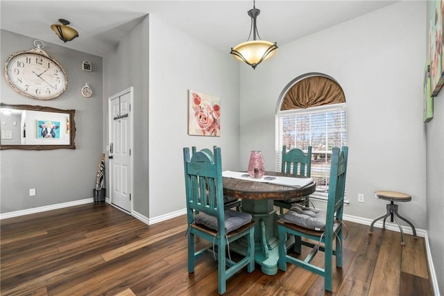 dining space with baseboards and wood finished floors