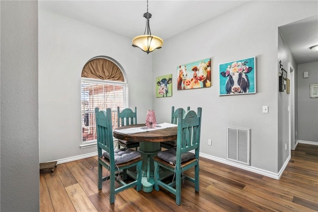 dining area featuring visible vents, baseboards, and wood finished floors