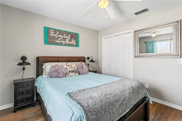 bedroom with a closet, visible vents, baseboards, and wood finished floors