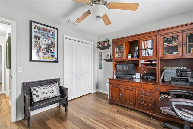 home office with baseboards, ceiling fan, visible vents, and wood finished floors