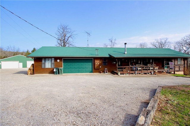 view of front of home featuring gravel driveway, metal roof, and a porch