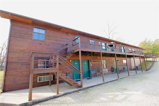 rear view of house with cooling unit, a deck, and stairs