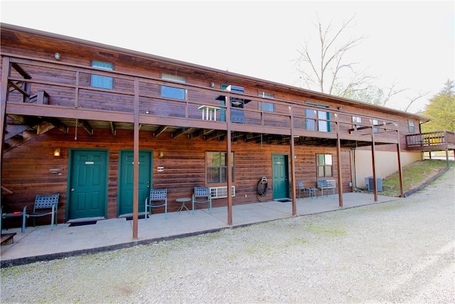 exterior space with central air condition unit, a patio, and a wooden deck