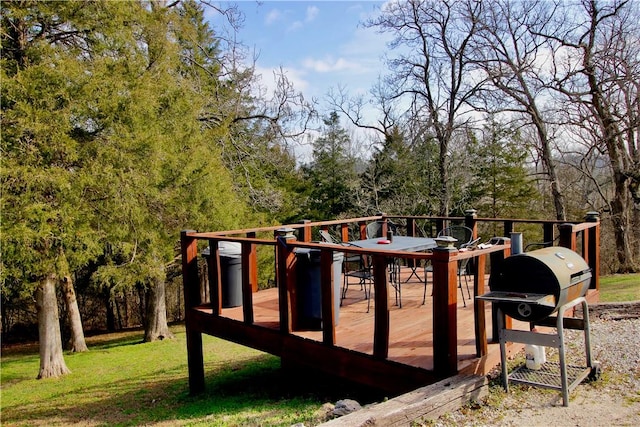 wooden terrace with a lawn and area for grilling