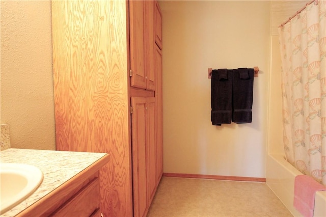 full bath featuring baseboards and vanity