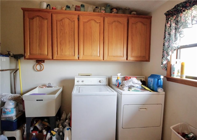 laundry area featuring cabinet space, a sink, and independent washer and dryer