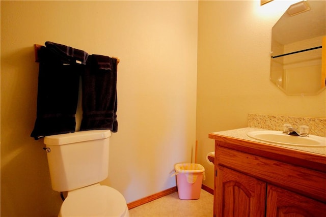 bathroom featuring vanity, toilet, and baseboards